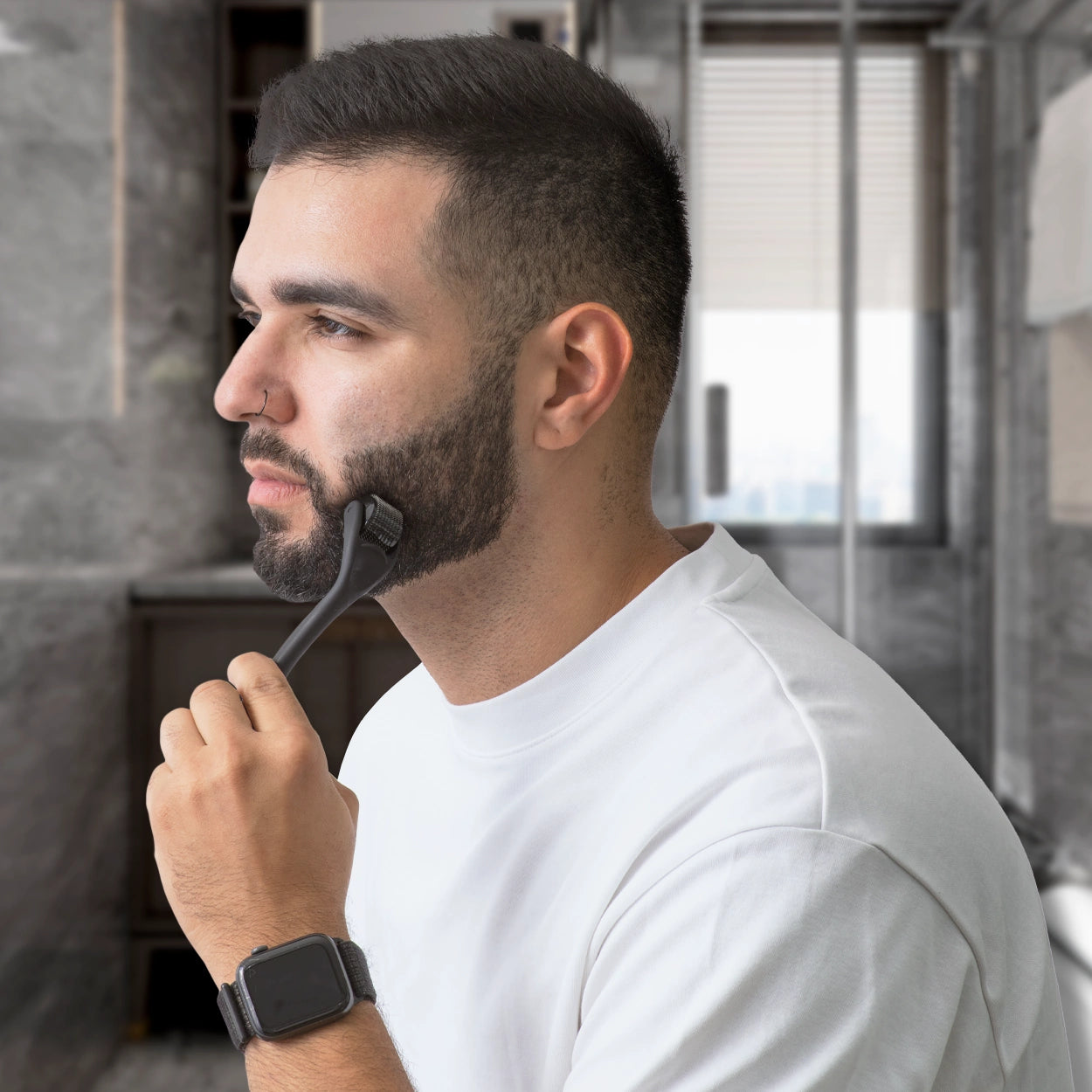 Lifestyle image of a man using a DermTech Derma Roller on his face to stimulate beard growth and enhance hair follicles. Discover how DermTechRoller helps men achieve thicker, fuller beards with at-home microneedling.