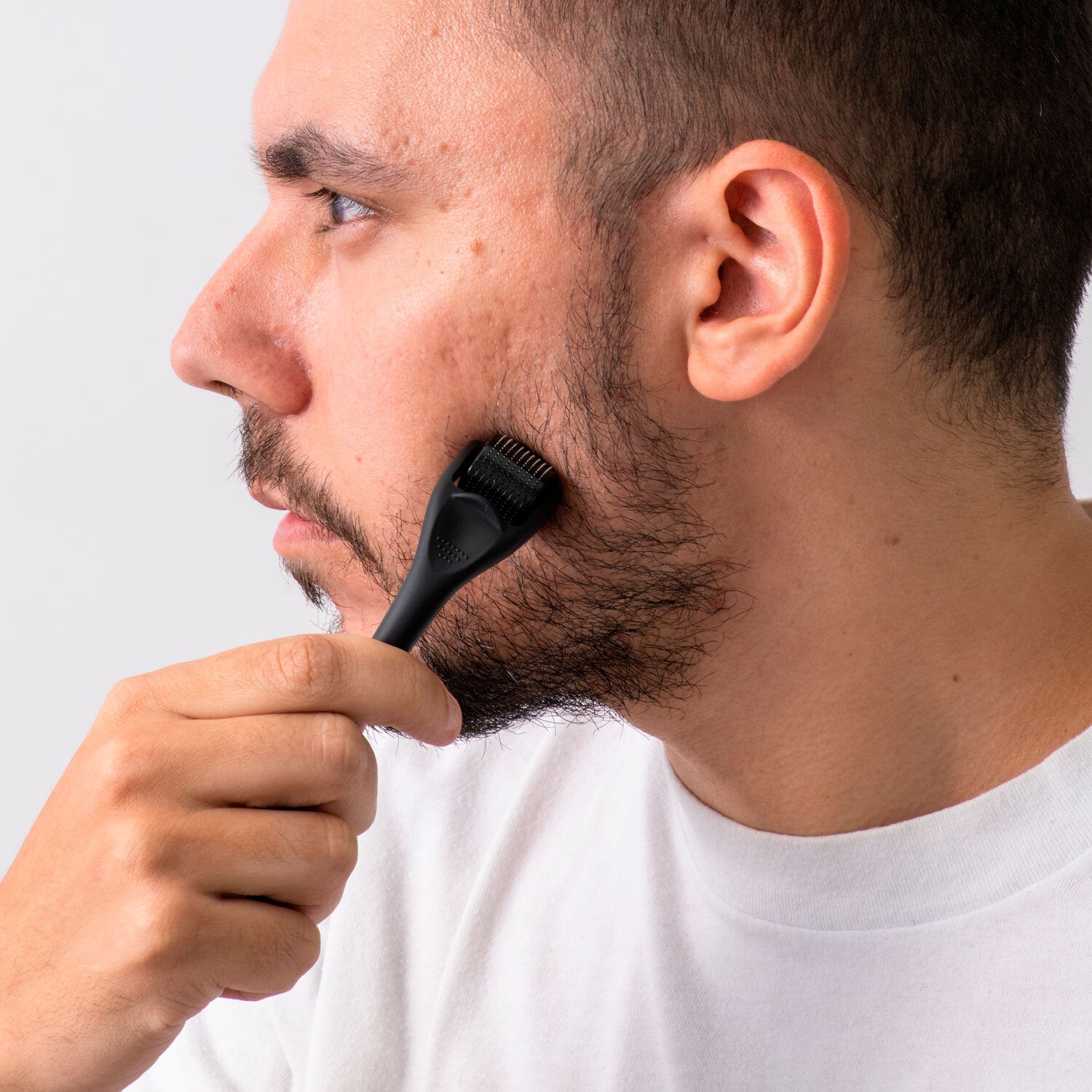 Image of a man using a DermTech Derma Roller in detail, showcasing the proper technique for effective hair growth and skincare with DermTech products.