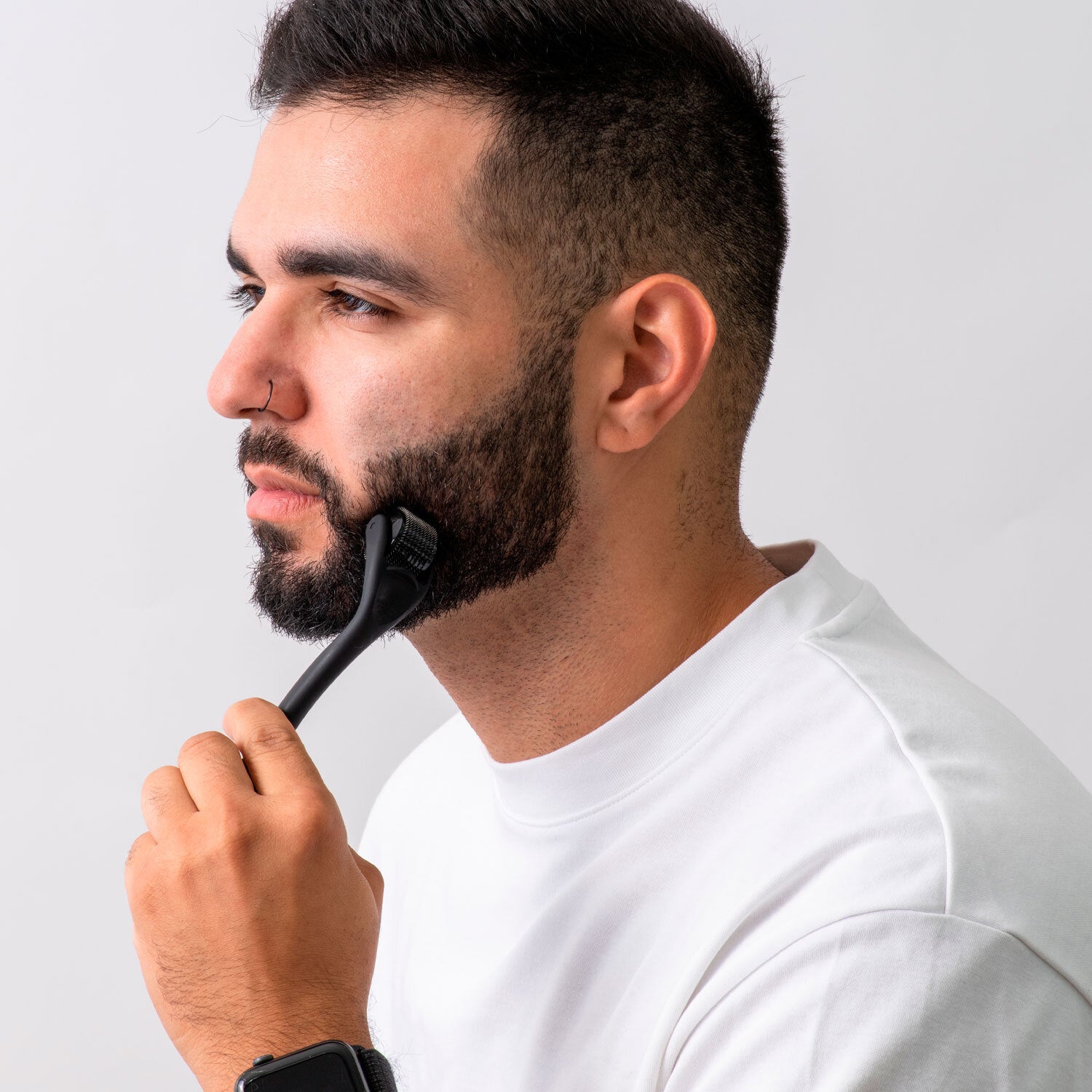 Image of a man with a beard using a DermTech Derma Roller, demonstrating effective beard care and hair growth stimulation for optimal grooming results.