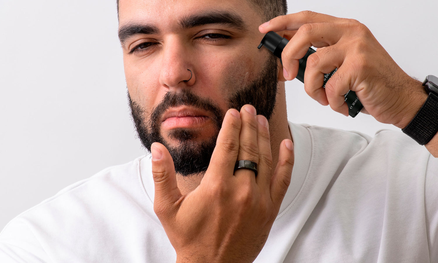 Image of a man applying DermTech Beard Promoter and Hair Serum to his beard, showcasing the product in use for enhanced beard growth and nourishment.