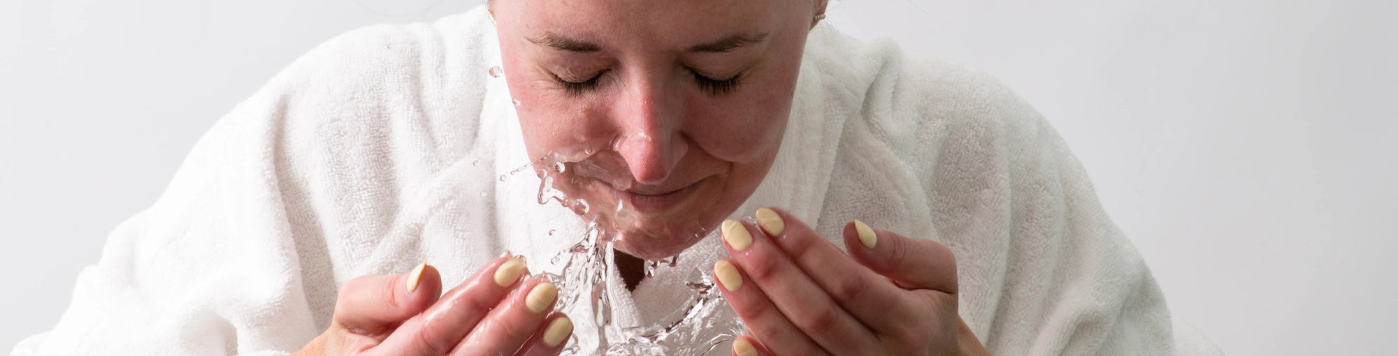 A woman cleansing her face before using a DermTech derma roller for microneedling. Prepping the skin properly enhances collagen production, improves absorption of serums, and maximizes benefits for wrinkle reduction, scar treatment, and skin rejuvenation. Ideal for at-home microneedling to achieve a smoother, more radiant complexion.