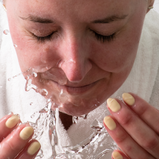 Woman washing her face as part of a skincare routine to prepare for microneedling or derma roller treatment. Discover the importance of clean skin for effective skincare with DermTechRoller.